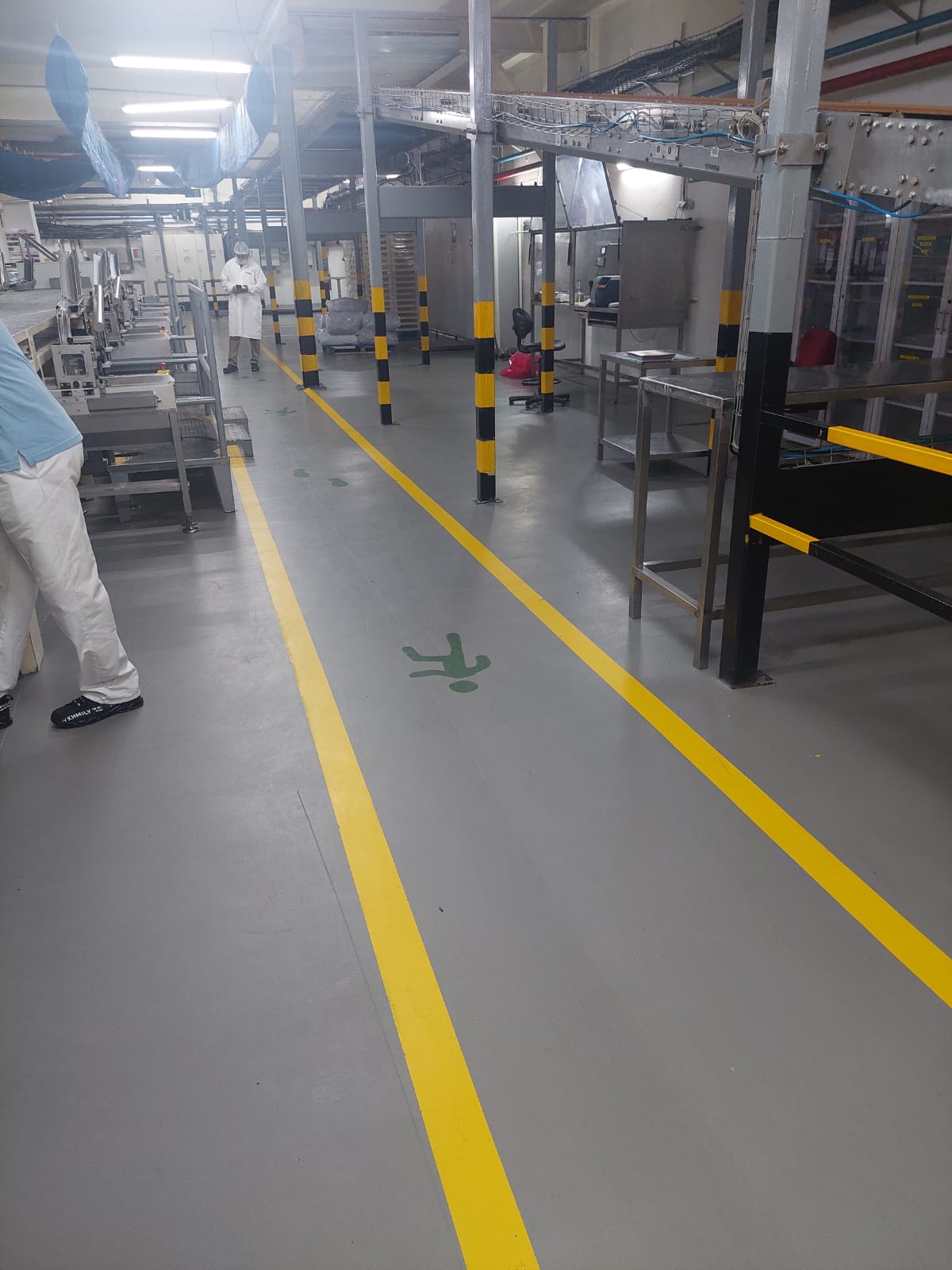 Marquage au sol jaune et revêtement gris dans une unité de production